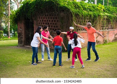 Indian Family Playing Blindfold Game In Park Or Garden, Multi Generation Asian Family Playing Outdoor Fun Games