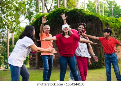 Indian Family Playing Blindfold Game In Park Or Garden, Multi Generation Asian Family Playing Outdoor Fun Games