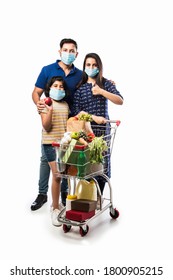 Indian Family Shopping With Kids During Virus Outbreak. Mother, Father And Daughter Wearing Surgical Face Mask Buying Grocery in Supermarket. Family In Shop.