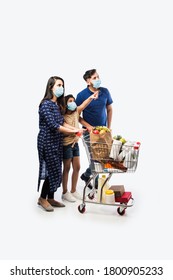 Indian Family Shopping With Kids During Virus Outbreak. Mother, Father And Daughter Wearing Surgical Face Mask Buying Grocery in Supermarket. Family In Shop.