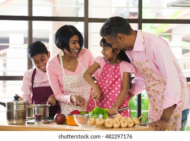 Indian Family Spending Quality Time Busy Cooking At Home

