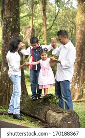 Indian Family Teaching Children To Climb