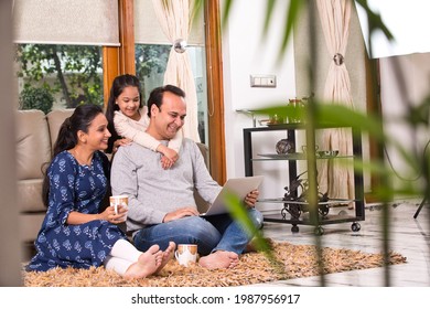 Indian Family Using Laptop In The Living Room At Home