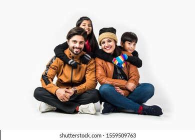 Indian Family In Warm Clothes Sitting Against White Background. Ready For Winter