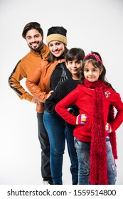 Indian Family In Warm Clothes Standing Against White Background. Ready For Winter