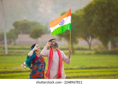 indian farmer couple saluting to national flag at agriculture field. - Powered by Shutterstock