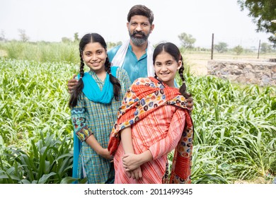 Indian farmer father standing with his two little daughters at agriculture field outdoor. Rural india concept,  - Shutterstock ID 2011499345