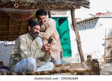 Indian Farmer Using Mobile Phone At Village.