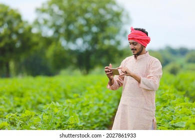 Indian farmer using smartphone at agriculture field. - Powered by Shutterstock