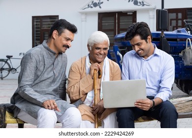 Indian farmers discussing paperwork with bank agent at village. - Powered by Shutterstock