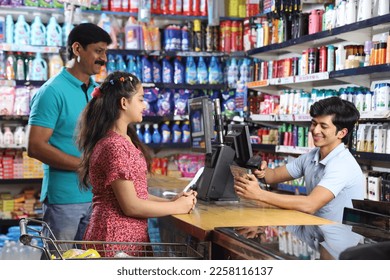 Indian father and daughter, after shopping in supermarket getting the billing done on the billing counter.  - Powered by Shutterstock