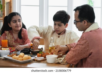 Indian Father And Daughter And Son Eating Indian Food, Using Hand, Panipuri, Curry Butter Chicken, Chicken Tikka, Biryani, And Naan Bread On Wooden Table, Indian Family 