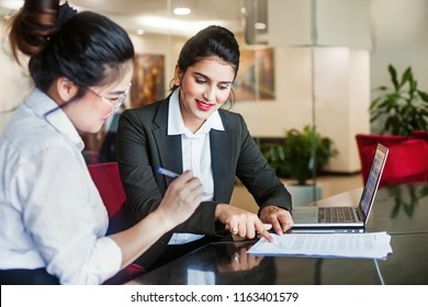 Indian female agent helping client sign the application document - Shutterstock ID 1163401579