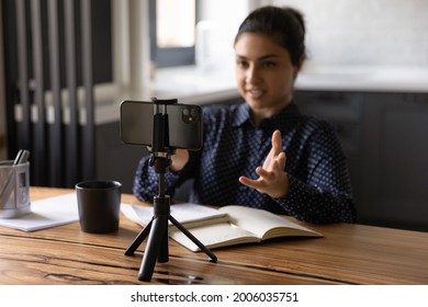 Indian Female Blogger Taking Video On Smartphone, Speaking At Web Camera. Online Teacher Holding Webinar From Home. Woman Using Mobile Phone On Tripod For Distance Call, Job Interview. Close Up