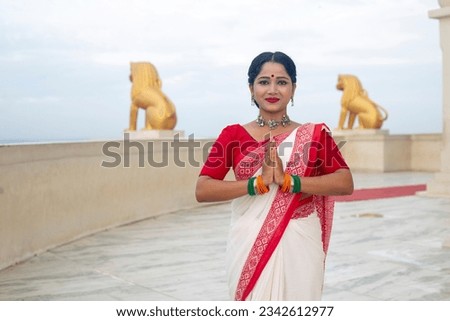Indian Female giving namaste or welcome gesture background Yellow lion statue at Dhauli Shanti Stupa in Bhubaneswar, Odisha, India. Incredible India