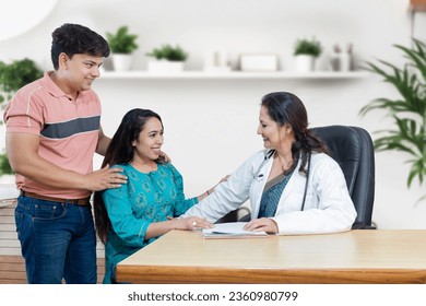 Indian female gynecologist doctor consulting young married couple patients in fertility clinic about IVF or IUI. Planning pregnancy concept. - Powered by Shutterstock