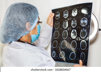 Indian Female Neurologist Examine A CT Scan Plate At A Healthcare Clinic 