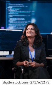 An Indian female software engineer or data scientist smiles during a technical briefing in a command center SOC. She is in a meeting analyzing AI code or cybersecurity data at night.