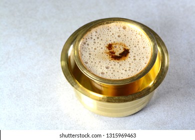 Indian Filter Coffee served in brass cup and saucer.