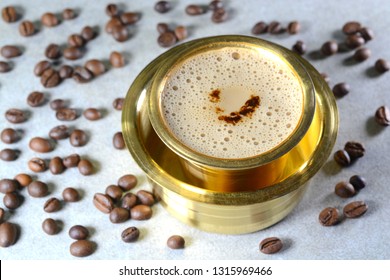 Indian Filter Coffee served in brass cup and saucer.