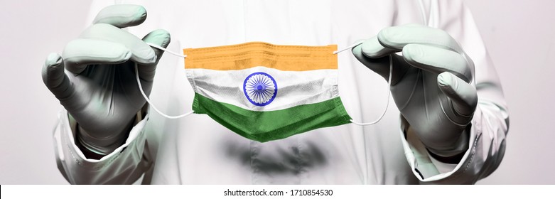 Indian flag on protective medical mask. Coronavirus Covid 19 pandemic outbreak in India. Quarantine. Mask mode. Close up of the doctor's hands suggest putting on a protective mask.  - Powered by Shutterstock