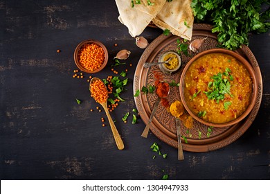 Indian food dal. Traditional Indian soup lentils.  Indian Dhal spicy curry in bowl, spices, herbs, rustic black wooden background. Top view.  Authentic Indian dish. Overhead. Flat lay - Powered by Shutterstock