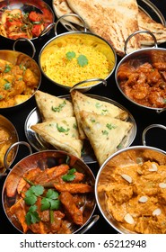 Indian food including curries, rice, samosas and naan bread.