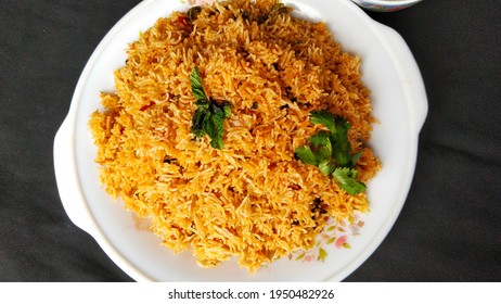 Indian Food Tomato Pulao Rice With Coriander And Mint Leaves On A Plate