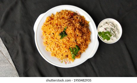 Indian Food Tomato Pulao Rice With Coriander And Mint Leaves On A Plate