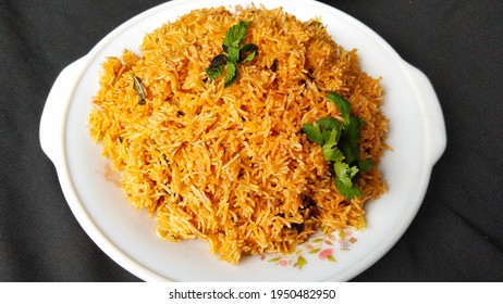 Indian Food Tomato Pulao Rice With Coriander And Mint Leaves On A Plate