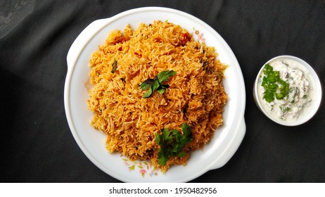 Indian Food Tomato Pulao Rice With Coriander And Mint Leaves On A Plate