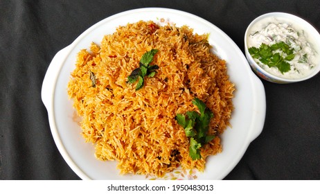 Indian Food Tomato Pulao Rice With Coriander And Mint Leaves On A Plate