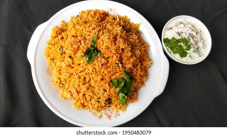 Indian Food Tomato Pulao Rice With Coriander And Mint Leaves On A Plate