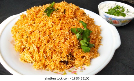 Indian Food Tomato Pulao Rice With Coriander And Mint Leaves On A Plate