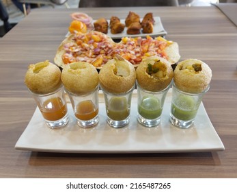 Indian Foods And Snacks Of Pani Puri Golden Balls With Spicy Sauces And Toasted Masala Prapad (paper Thin Wheat Wafer)  On A Table