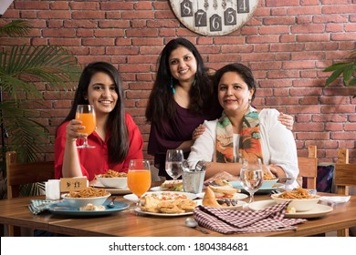 Indian Friends Eating Or Dining In Restaurant. Asian People In Face For Get-together, Reunion Or Celebrating Party. Coffee Shop Celebration Friendship Togetherness Concept