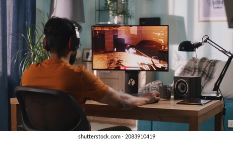 Indian gamer playing shooter at home - Shutterstock ID 2083910419