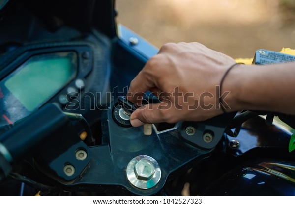 Indian garage worker\
repairing bike  switch