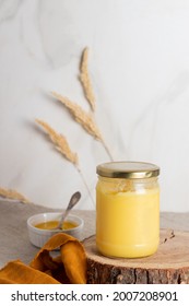 Indian ghee clarified butter desi in glass jar on wood slice. 