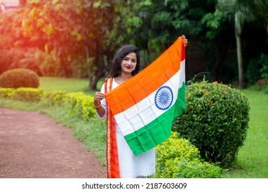 Indian Girl Celebrating Independence Or Republic Day. Woman Saluting Wear White Kurta, Holding Indian Tricolor Flag.