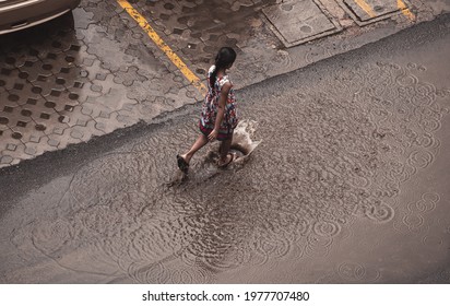 An Indian Girl Splashes The Rain Water In A Puddle After Tauktae Cyclone Reaches Delhi, India Causing Days Of Heavy Rain And Coldest Summer Temperature In History.