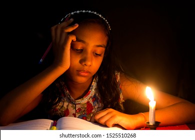 Indian girl studying in candlelight