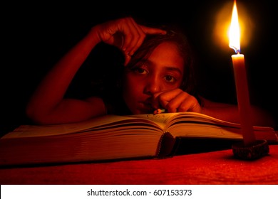 An Indian Girl Studying In Candlelight, No Electricity, Blackout 