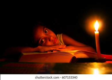 An Indian Girl Trying To Study In Candle Light, Electricity,