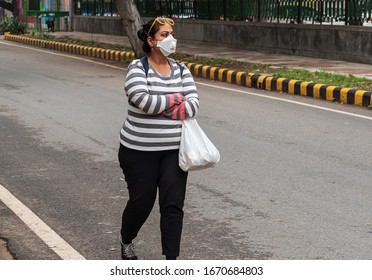 An Indian Girl Walking On The Road In Delhi, Lady Wearing An N 95 Mask In India After The Global Spread Of Corona Virus Pandemic Disease In Asian Countries. Air Pollution And Covid 19 Concept.