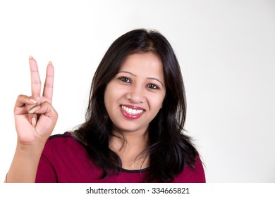 Indian Girl Wearing Red T Shirt  Showing Victory Shot Against White Background