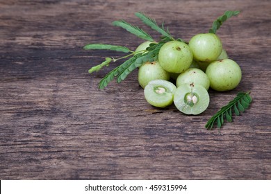 Indian gooseberry or amla fruit with leaf on wooden table top