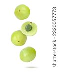 Indian gooseberry fruit (amla emblica) falling in the air isolated on white background.