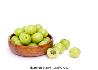Indian gooseberry fruit or Amla ( phyllanthus emblica ) in wooden bowl with sliced isolated on white background. Space for text