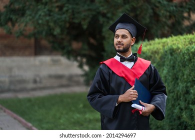 Indian Graduate In Graduation Robe With Diploma In University Campus Copy Space.